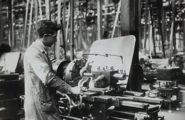 foto antiga com homem mexendo em máquina industrial