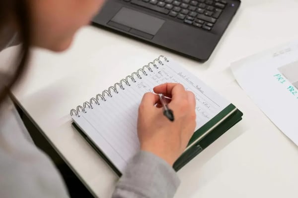 mulher escrevendo em caderno