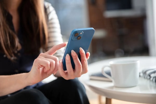 A imagem apresenta as mãos de uma mulher branca que tem entre elas um iphone. O tema do artigo é tecnologia e inovação.